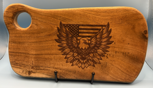 Wooden cutting board with an engraved eagle and American flag design on a gray background