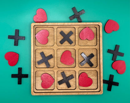 Wooden tic-tac-toe board with heart-shaped game pieces on a teal background