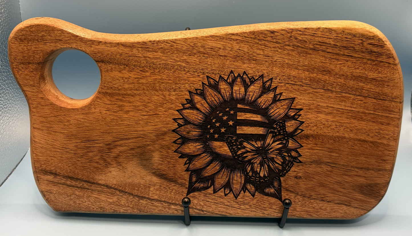 Wooden cutting board with laser-engraved sunflower design on a gray background