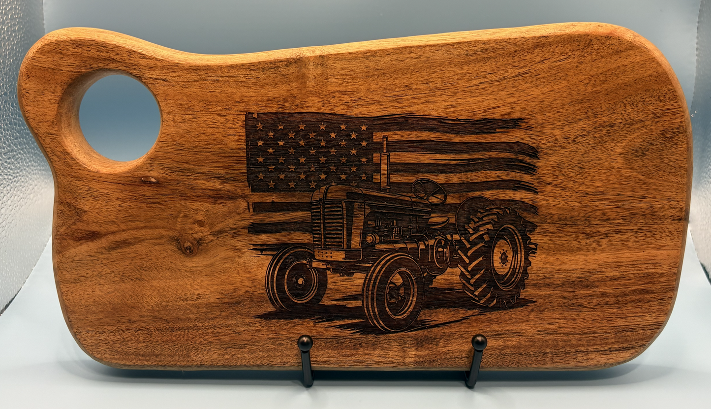 Wooden cutting board with engraved tractor and American flag design on a white background